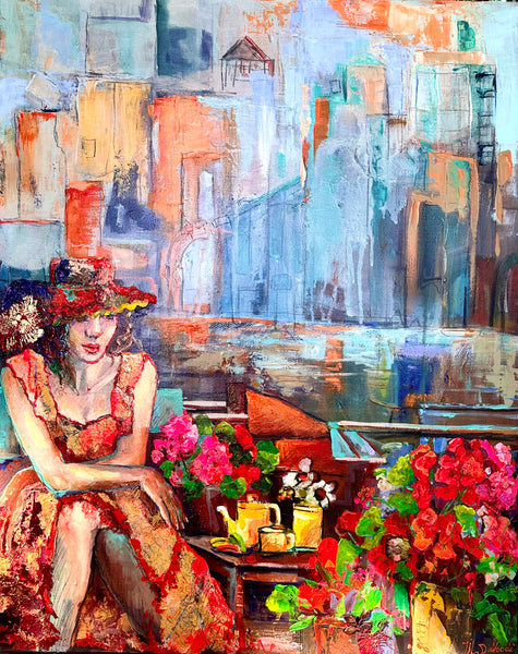 woman in a hat and red dress sitting at a riverside cafe with a teapot and cup of tea, two flower bouquets nearby behind her you can see the city skyline